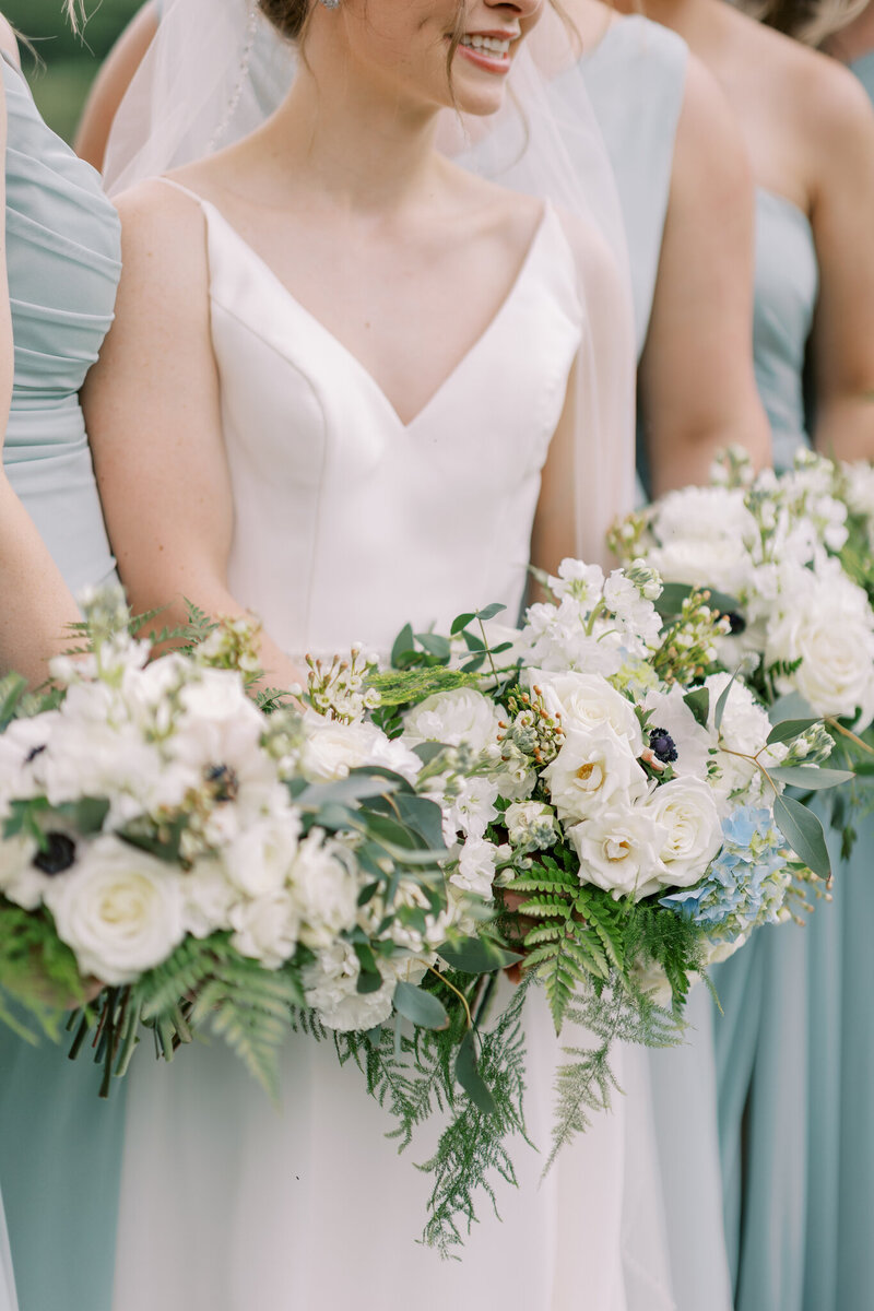Bridal party stands together with bouquets
