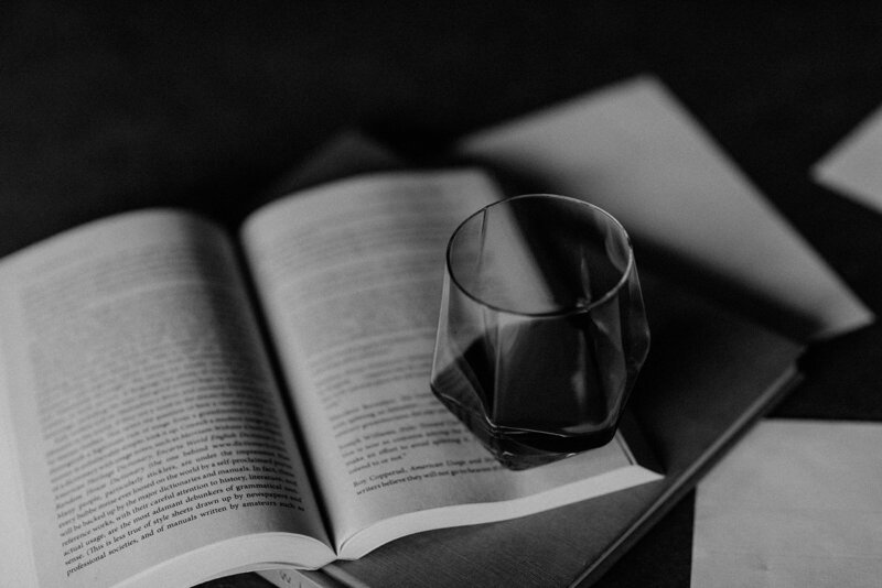 A black and white image of books and resources about website copywriting below a glass of wine