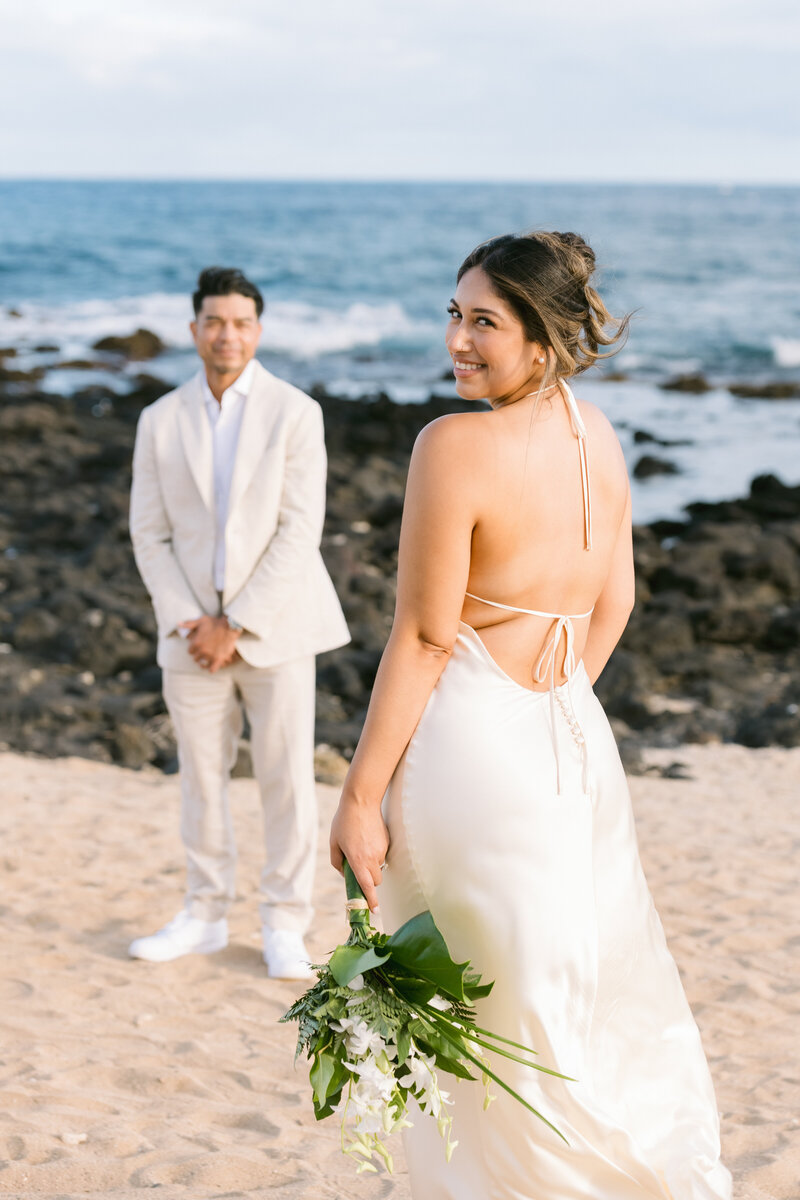 A couple embraces against the stunning backdrop of Sandy Beach, Oahu, celebrating their wedding with the sound of waves crashing nearby.