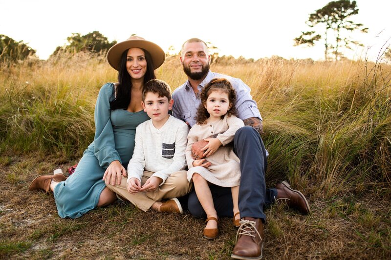 Family sitting in a field and looking at new jersey family photographer