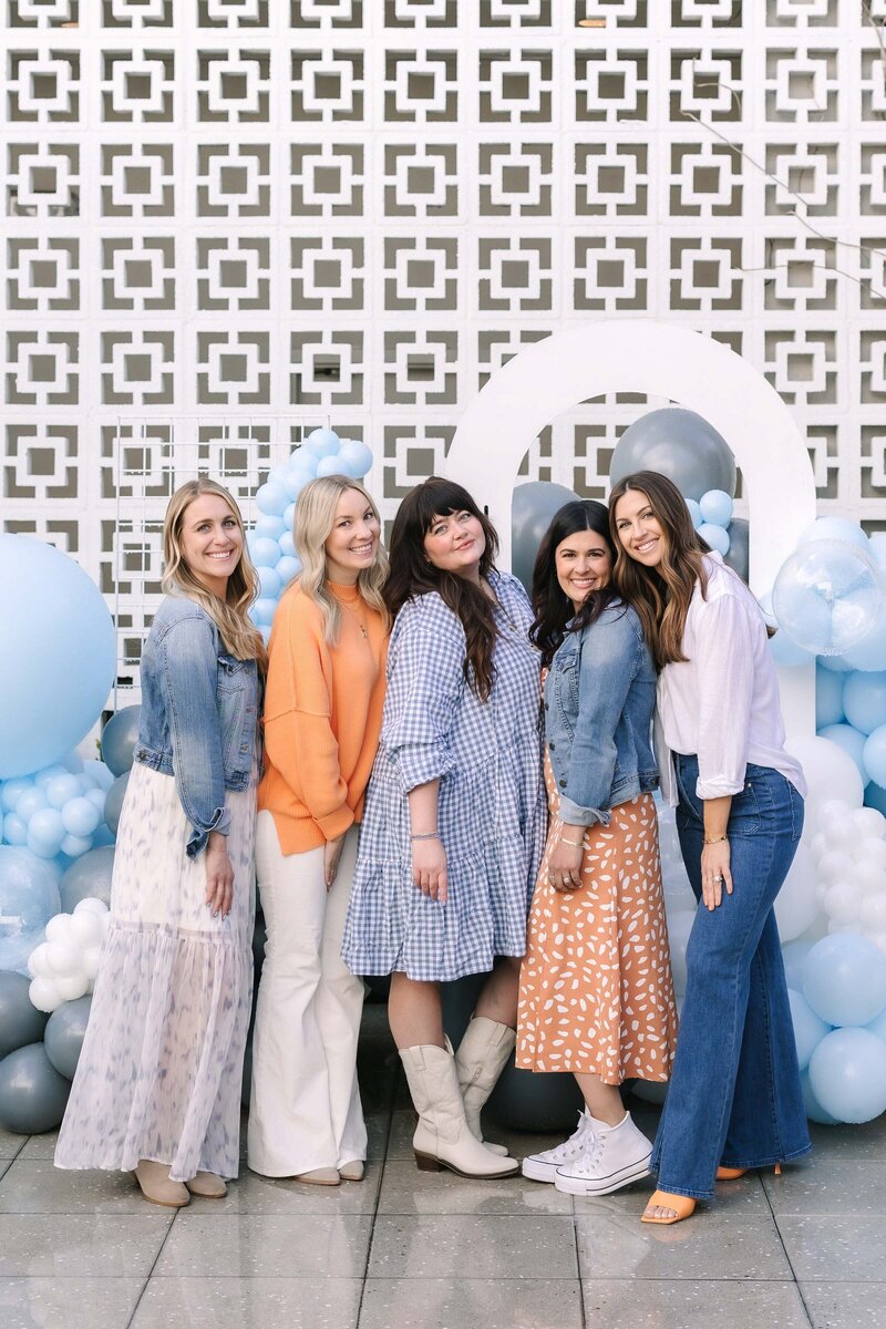 A group of Besties pose in front of the Hart and Main breezeblock wall