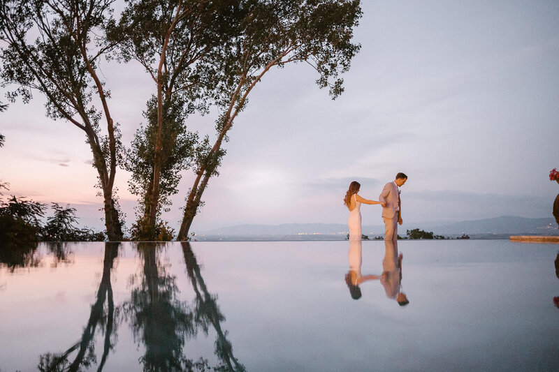 Bride and groom reflection on the pool of Villa Cicolina
