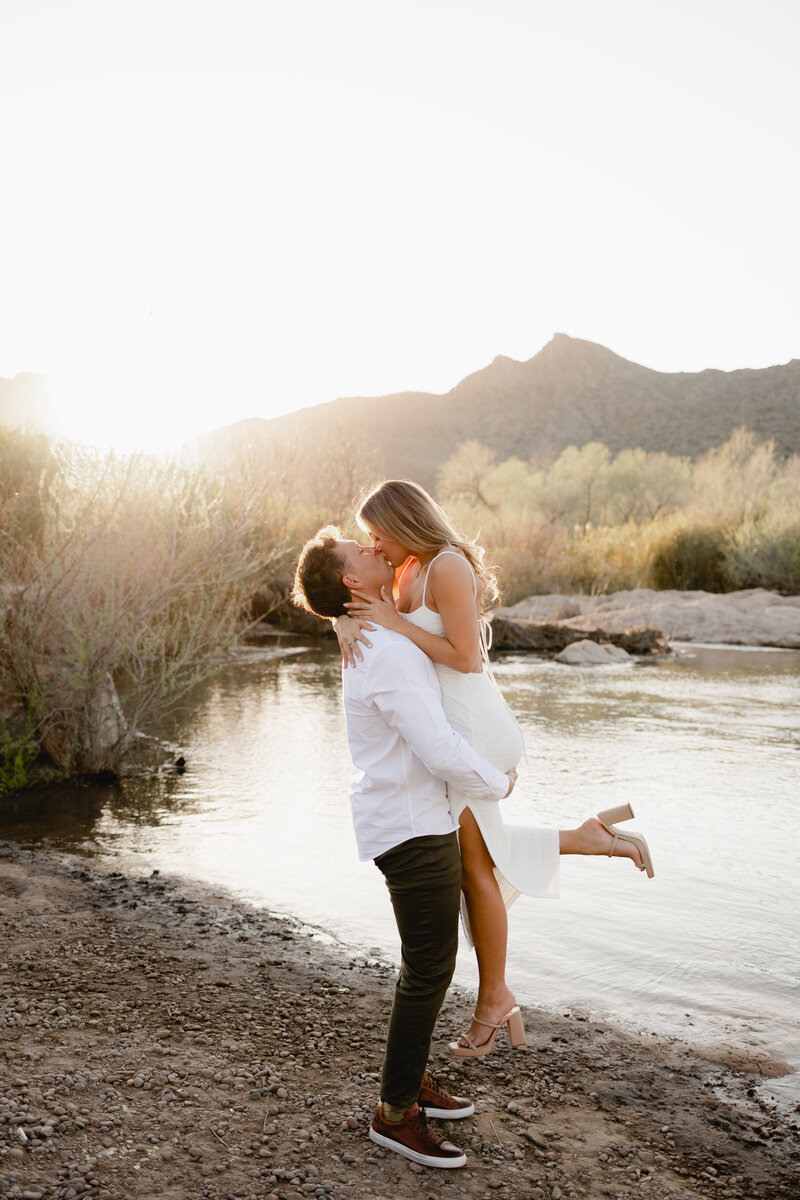 couple kissing during golden hour engagement session at the Salt River in Arizona