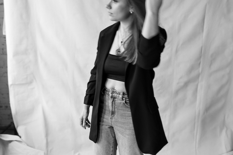 black and white photo of a woman wearing a blazer and jeans
