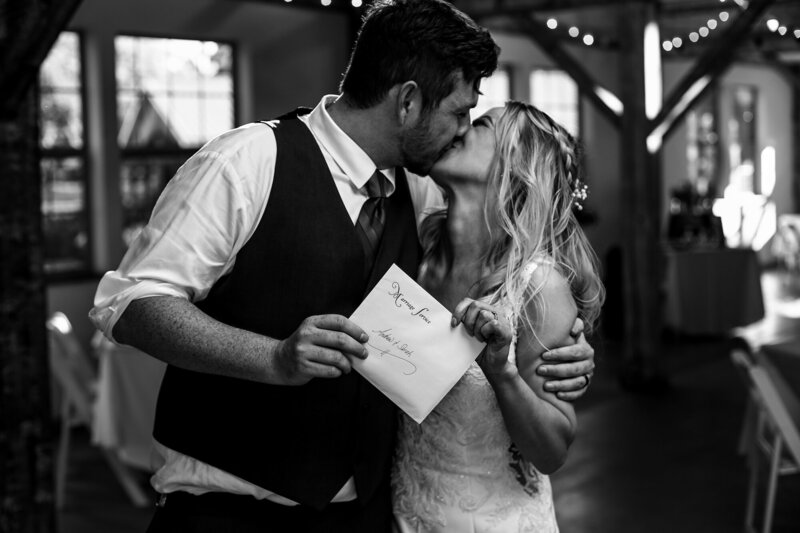 Couple kisses as they show off their marriage license at their Quincy cellars wedding