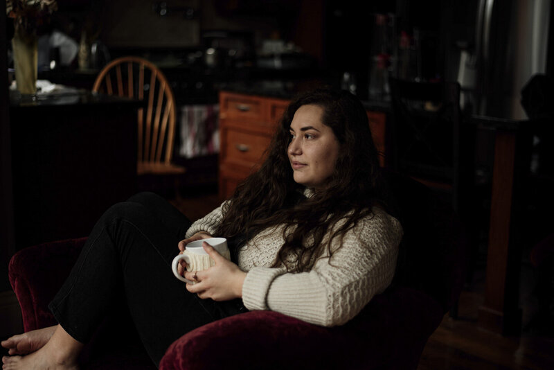 girl sitting on a couch with a mug of coffee