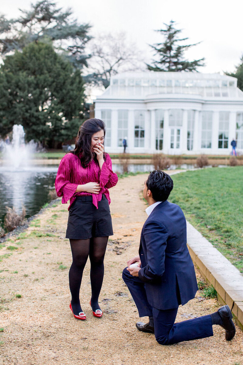 Man bending down on one knee, proposing to his girlfriend at their West London Proposal Shoot