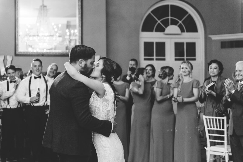 black and white photo of couple kissing during first dance at wedding reception