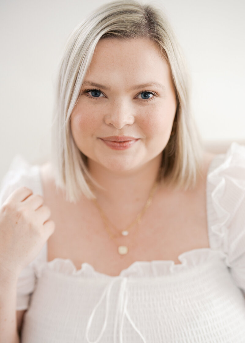 Woman smiling in white dress for a close up portrait