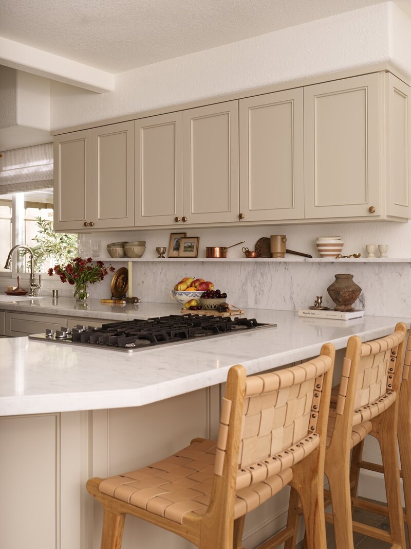 painted cabinets with marble countertops and backsplash and creamy cabinets