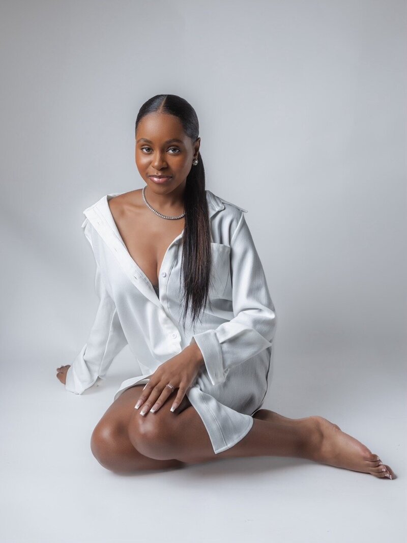 Singer Vanessa Dejean posing in white button up shirt.