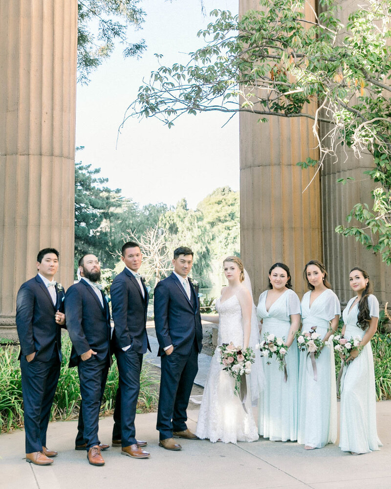 Bride + Groom standing with both sides of their wedding party