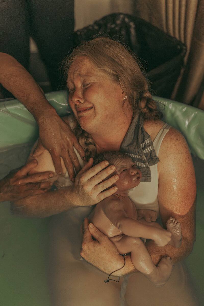 Raw emotional moment during waterbirth as Savannah documents a new mother holding her baby.