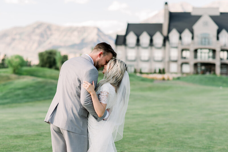 Sweet, romantic photo of a couple. He is carrying her in his arms while walking across Sleepy Ridge  Golf Course towards the Venue. Photo taken by Utah Wedding Photographers Andria Joleen Photography