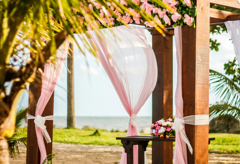 Outdoor wedding ceremony site with pink themed cloths and florals