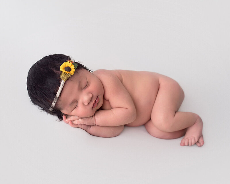 Newborn photo of beautiful baby girl with sunflower headband