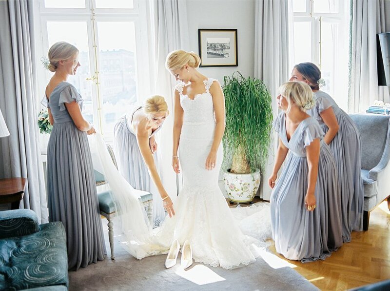 0012_Bridesmaids-helping-the-bride-put-on-her-Ida-Lanto-wedding-gown-1