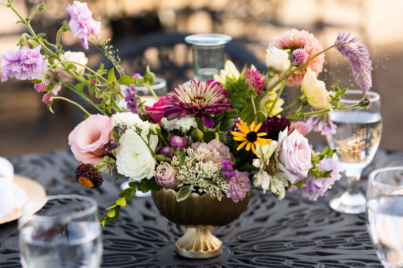 Floral centerpiece arrangement on dining table with water glasses