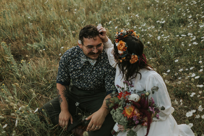Vintage stylish elopement couple in field of wildflowers
