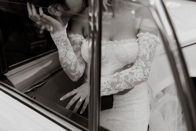 Bride and groom kissing in vintage car