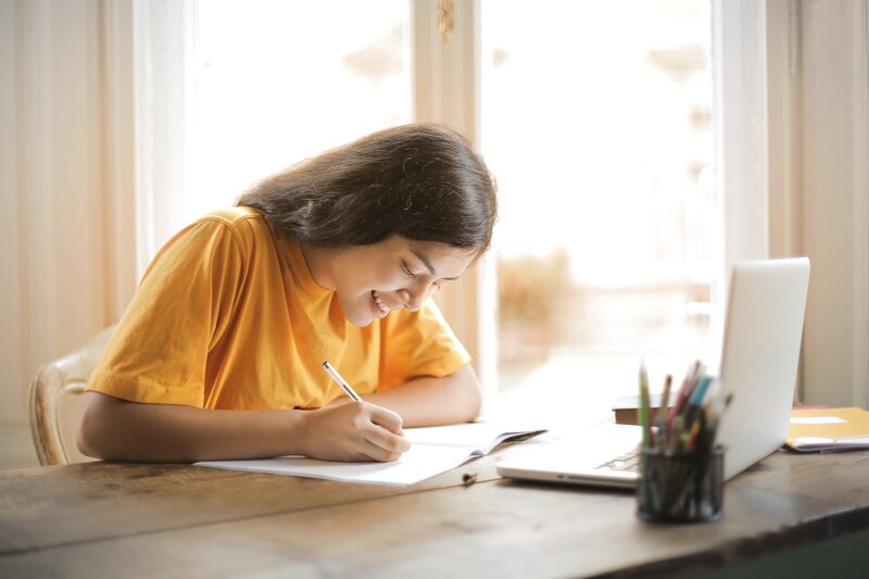 happy student learning from home using her laptop