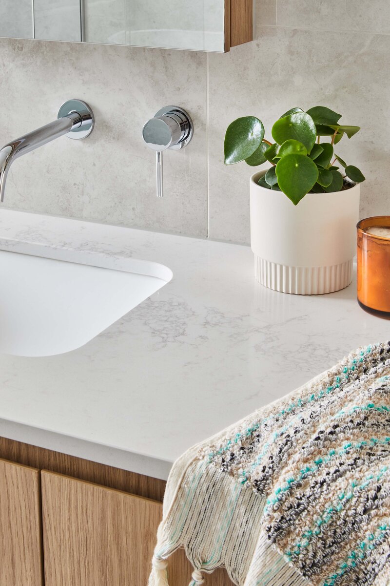 Modern bathroom vanity with stone benchtop, chrome tapware, indoor plant and textured towel | interior design project Brighton