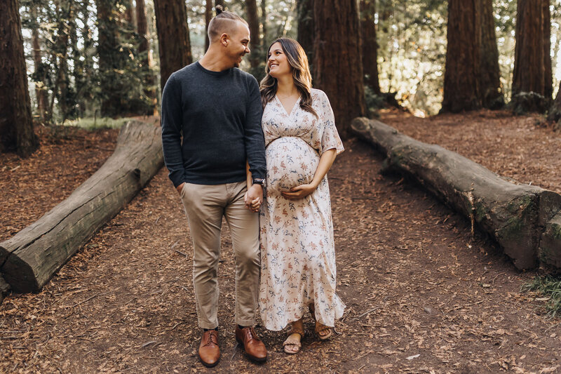 Pregnant mom and husband walk in the redwoods in Oakland Emily Woodall Photography