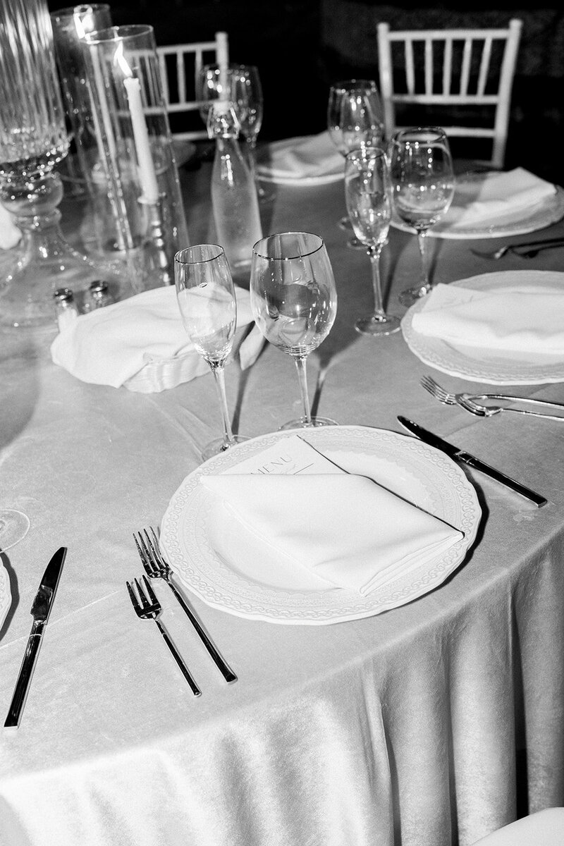 Candid black and white photo of wedding reception table settings showcasing documentary wedding photography in California