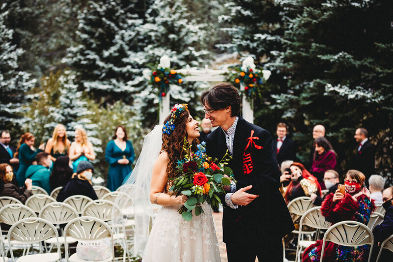 a photo of a winter wedding as the bride and groom walk down the aisle in Vermont