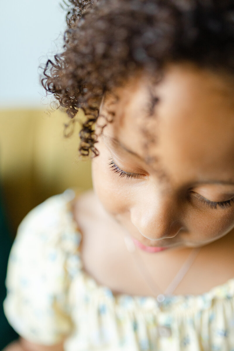 A close up image of a girls eyelashes and curls during an in home family session.
