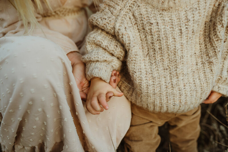 mother holding son's hand close up