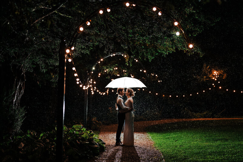 Groom and bride under umbrella