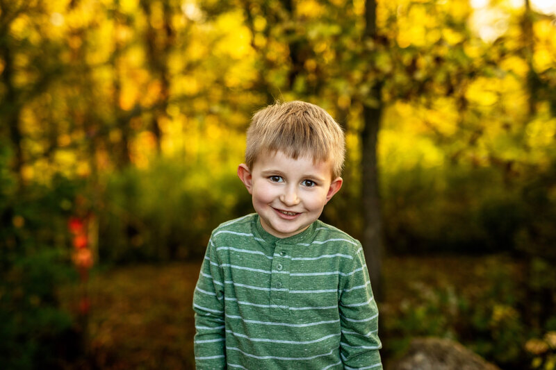 Little boy standing in woods with pretty light