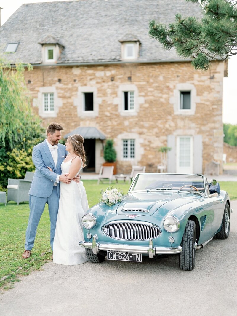 bride and groom close to luxury car