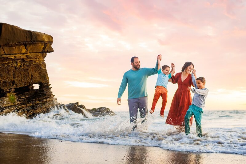 Family splashing together in the ocean in San Diego