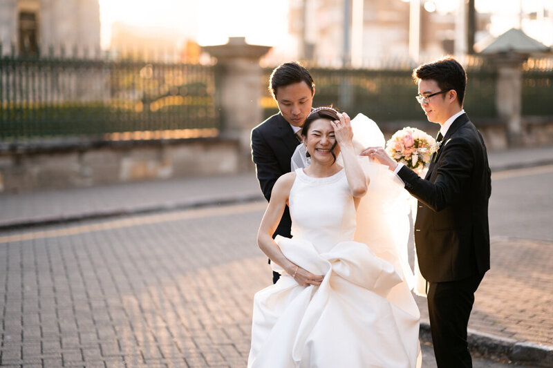 Groom and Best man helps bride lift her wedding gown