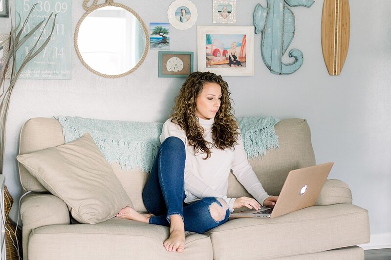 Coastal decor in living room on tan coach with macbook pro