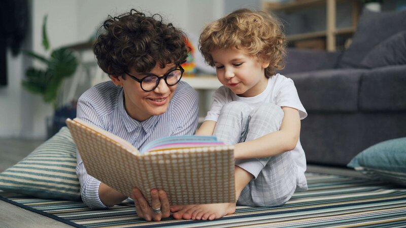 small student and tutor reading together