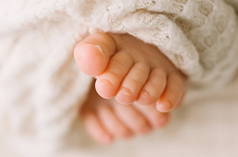 A close up image of newborn baby toes