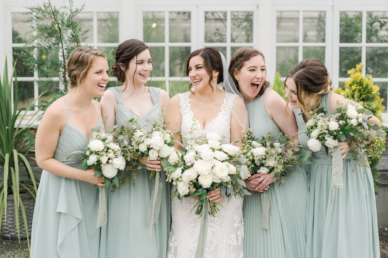 bridesmaids and bride look at eachother and laugh
