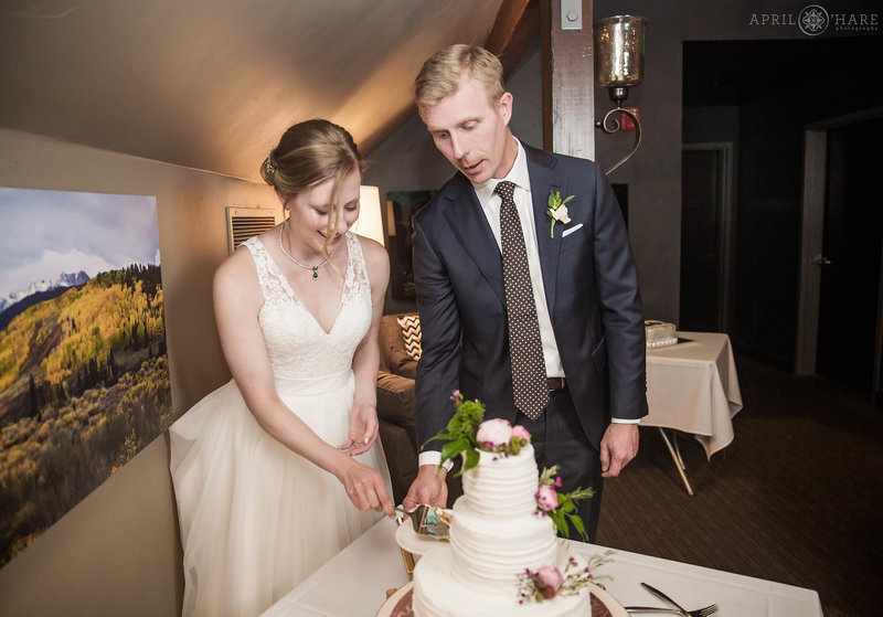 Bride & Groom cut their white wedding cake in the private dining room at Aurum restaurant in Steamboat