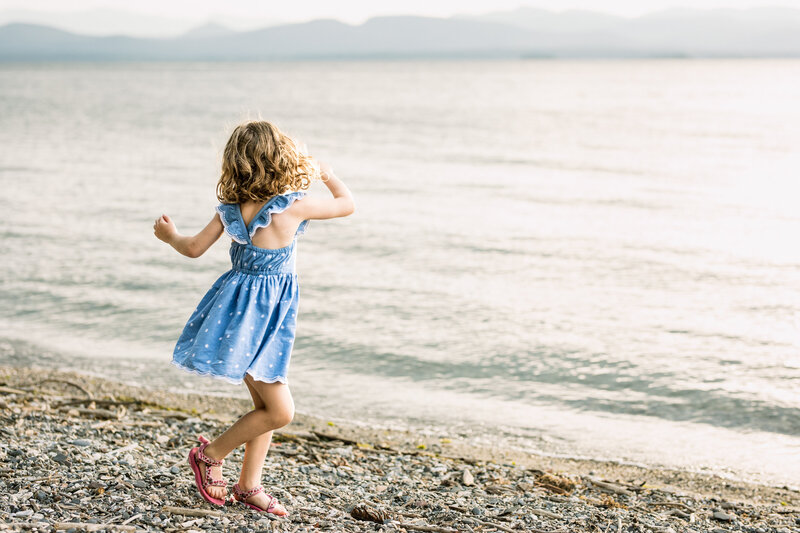 A 4 year old dances on a rocky beach Vermont Family Photographer