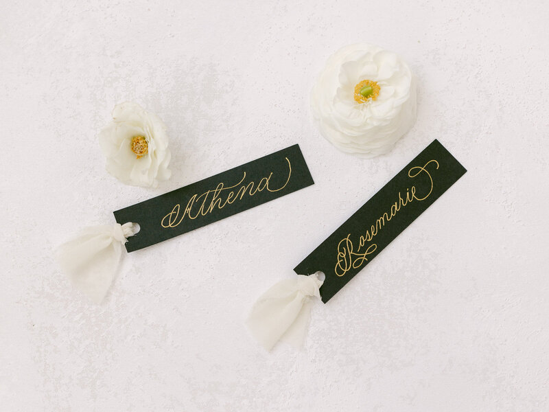 Name tags elegantly written in shimmering gold calligraphy ink