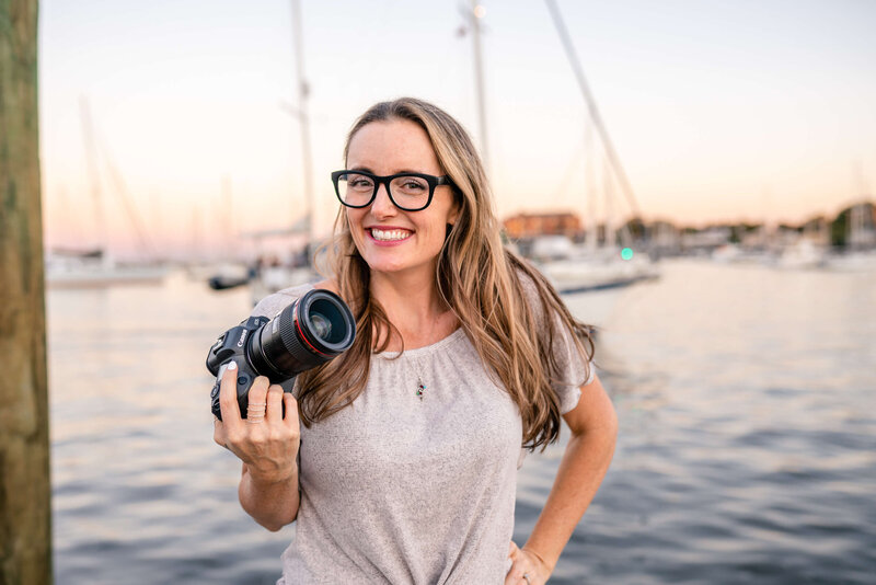 Photographer Kelly Eskelsen with camera in front of boats in downtown Annapolis, Maryland.