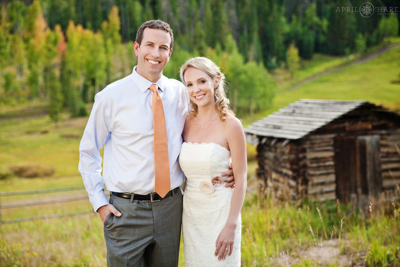 Beautiful Fall Wedding Portrait with Rustic Cabin in the backdrop at Snow Mountain Ranch YMCA in Winter Park