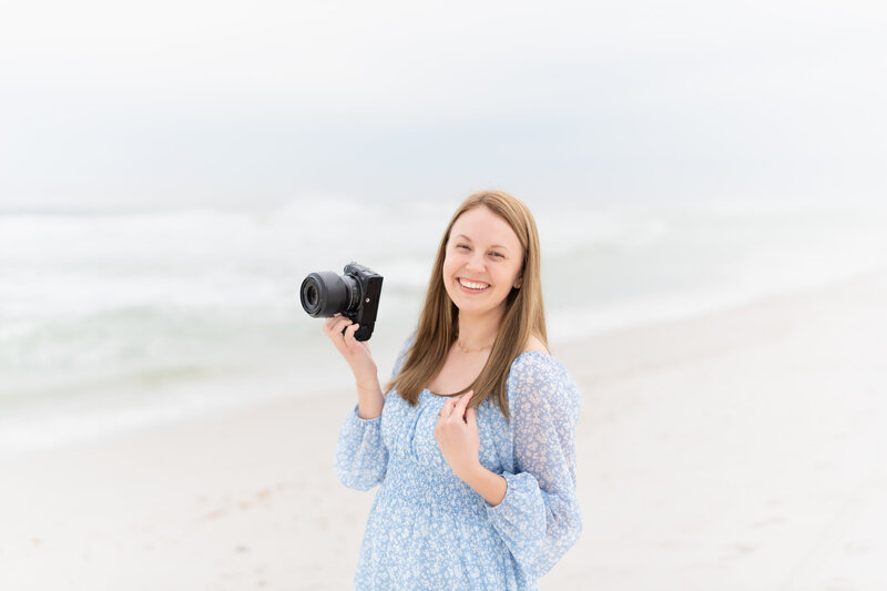 Colorado Springs Photographer smiling while holding her camera in her hand