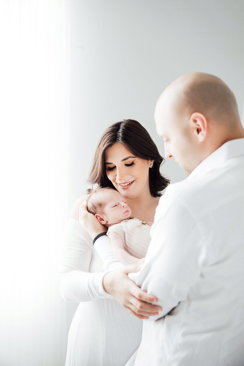 Parents looking at newborn baby taken by new jersey family photographer