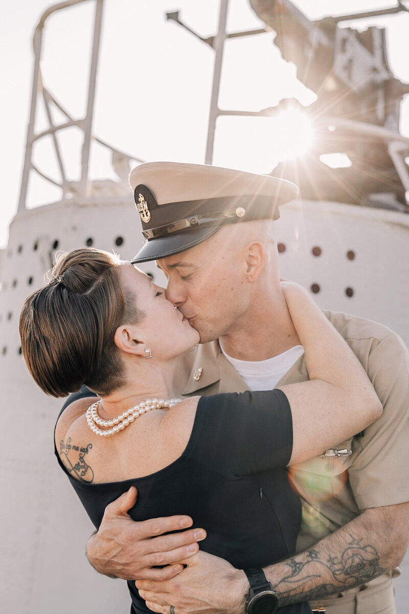Chief Petty Officer embraces wife in a kiss after pinning ceremony.