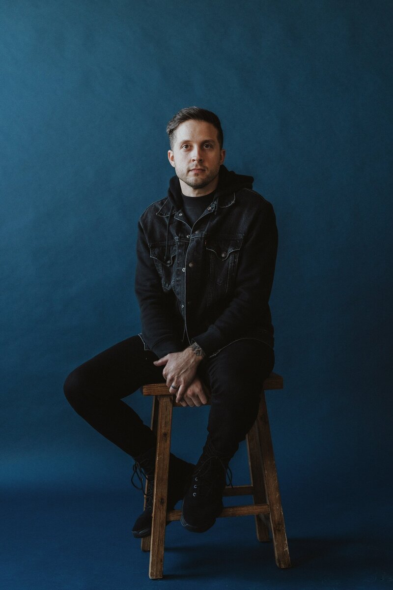 Toby sitting on stool with blue background-FillmCo