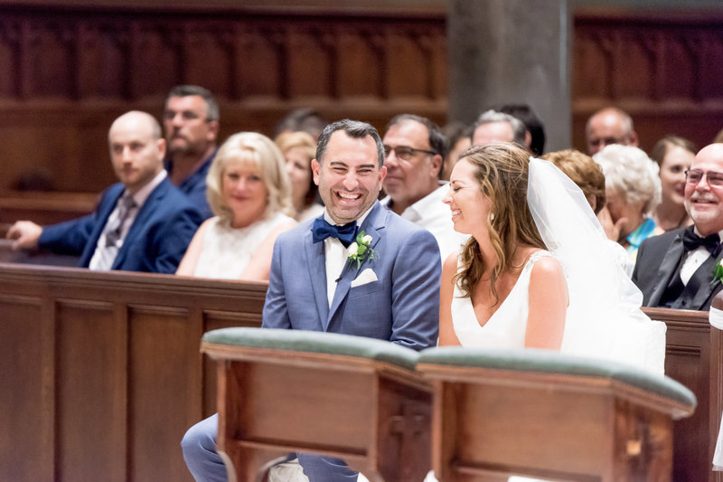 A bride and groom share a laugh during their wedding ceremony